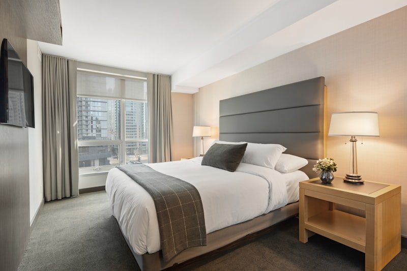 Clean modern bedroom with neatly made bed ready for inspection